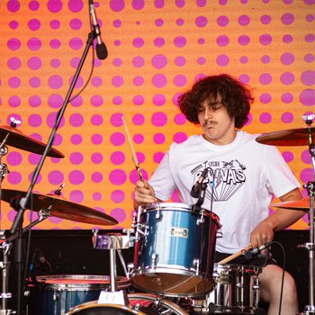 A boy playing the drums on stage