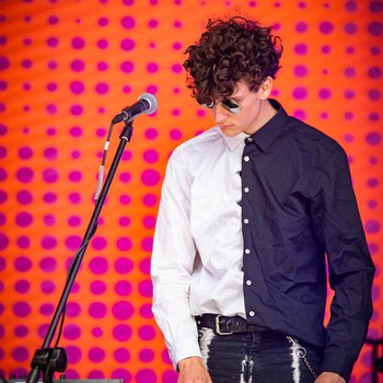 A boy playing the keyboard wearing a navy and white shirt