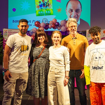 A group of authors smiling on stage