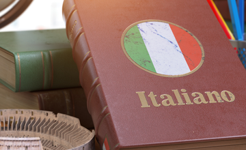 Book with title Italiano resting on table with model of roman amphitheatre