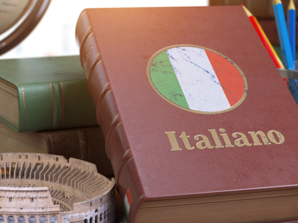Book with title Italiano resting on table with model of roman amphitheatre