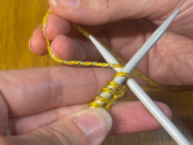 Working yarn being wrapped around a knitting needle