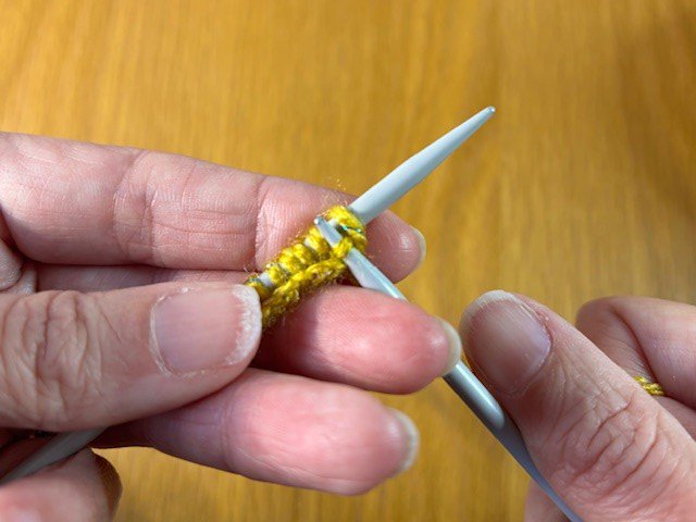 Photo of knitting - second stitch being pulled through first stitch