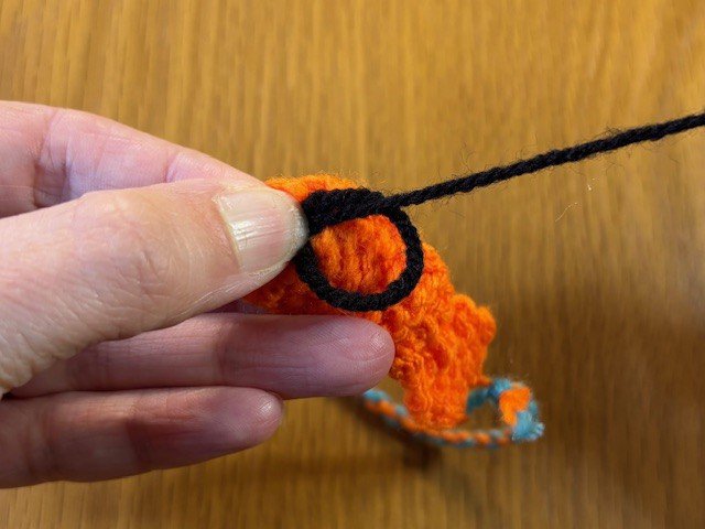 A French knot being tightened