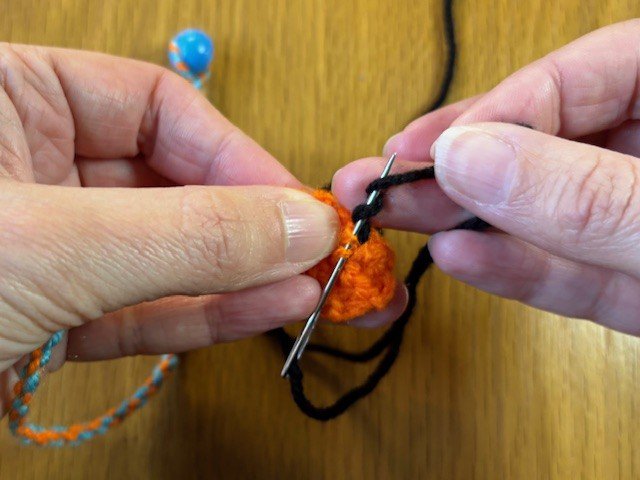 Wool wrapped around a sewing needle three times