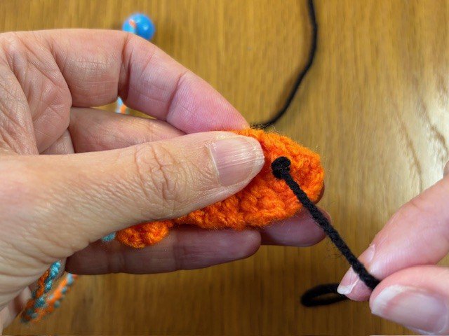 A French knot with a loose tail of yarn