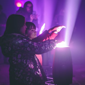 Children holding their hands over a projection of light.