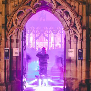 Church doorway with purple light and a person stood in the middle.