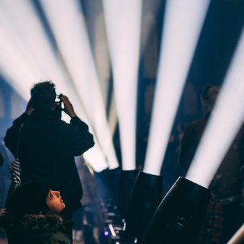 A shadow of someone taking a photo of light projections.