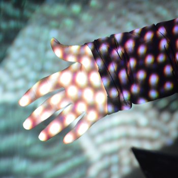 Light projection of small circles projected on to a hand.