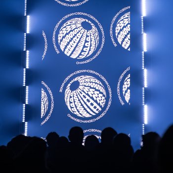 Crowds in a dark church in front of a large screen