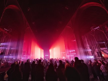 Crowds in a church with red lighting