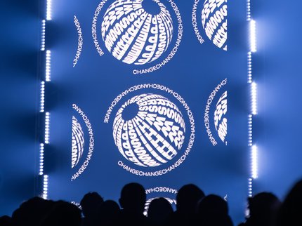 Crowds in a dark church in front of a large screen