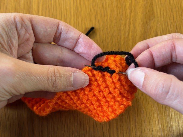 Yarn wrapped around a sewing needle three times