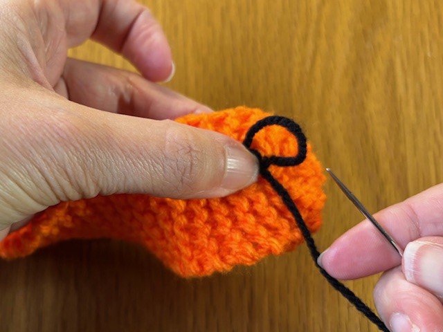 A French knot being pulled tight