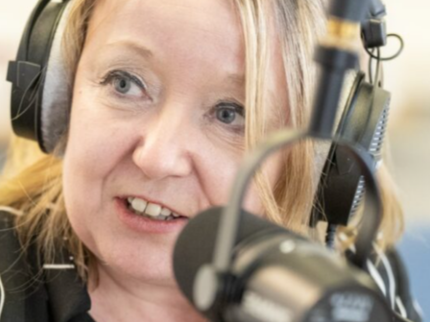 An image of a blonde woman talking into a microphone with text "LOVE READING" on the left