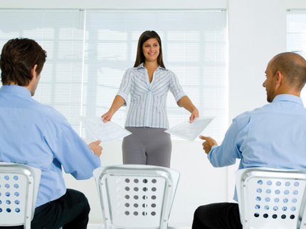 woman handing sheet of paper to men