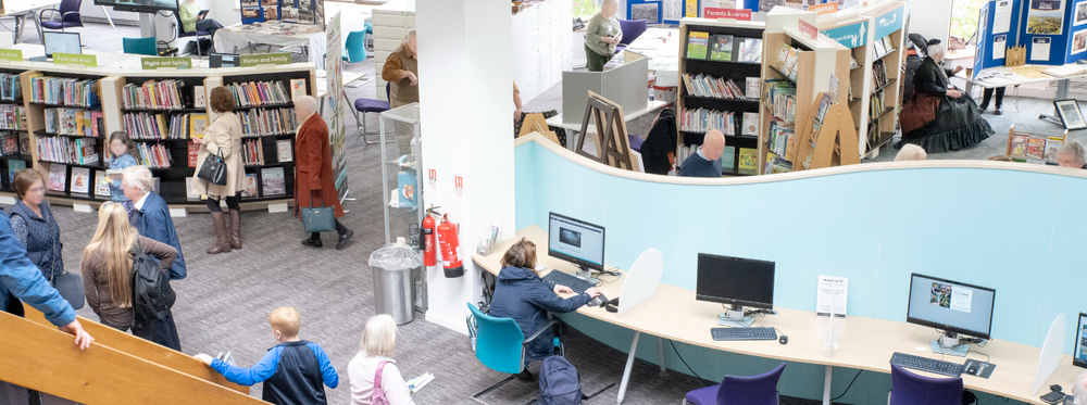 A wide shot showing lots of people in Mansfield Central Library, enjoying the space and using the public computers