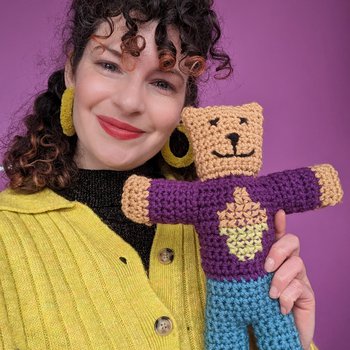 designer Megan Crook holding a crochet Brave Bear