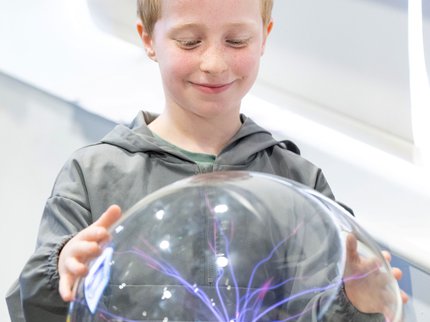 boy with hands on plasma ball