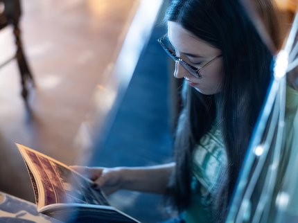 The reflection of a young woman reading