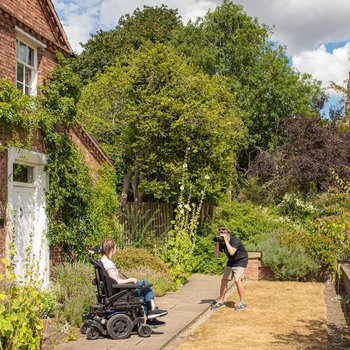 A man taking photos at Clumber Park with a young person using a wheelchair.
