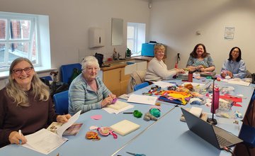 a group of women doing crafts around a table