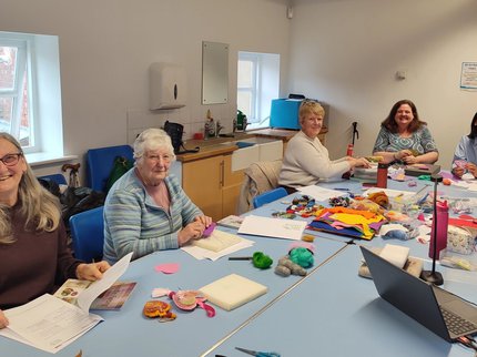a group of women doing crafts around a table