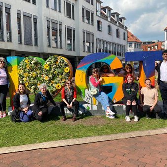 People sat on grass in front of a sign