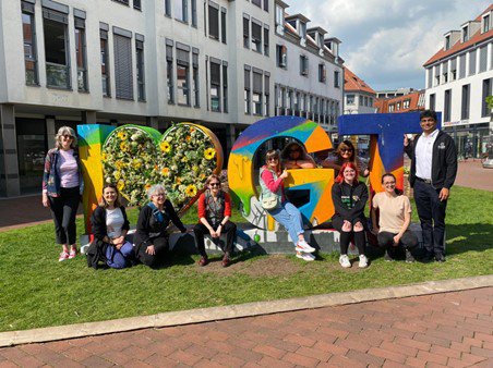 A group of Inspire staff members posing around a colourful I Love GT sign.