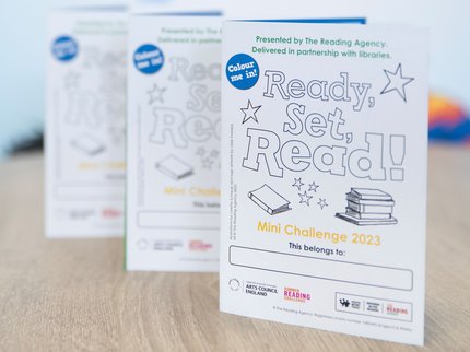 Three of the sticker collectors folders that children get when they join the Mini Challenge