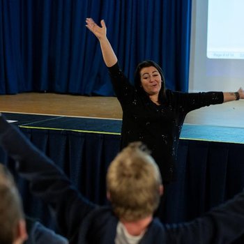 Sing with Friends Tutor with arms in air.