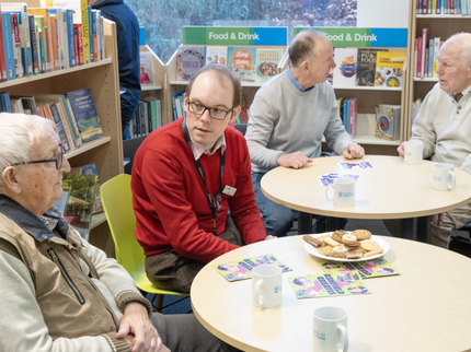 Group of people sat chatting and drinking tea at a Places of Welcome group