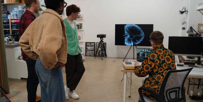 Young people gathered around a computer screen