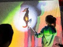 Child using a seahorse stencil to make a shadow
