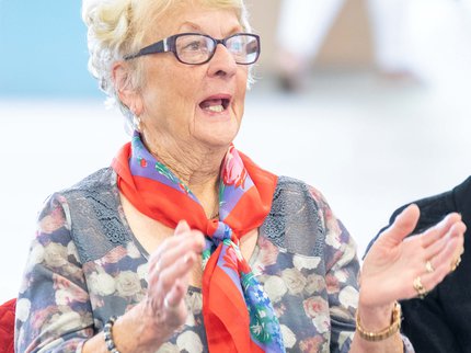 Woman clapping and singing along to music in a library