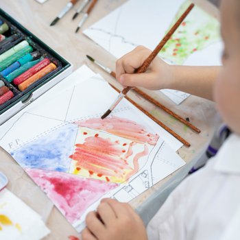 Child painting a tile from the map artwork