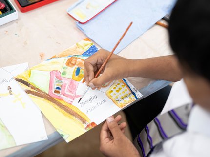 A child creating art work on a section of an historical map of Skegby