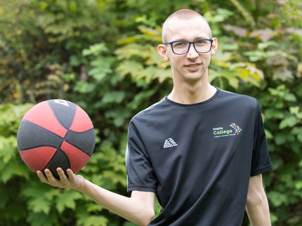 A young person holding a basketball.