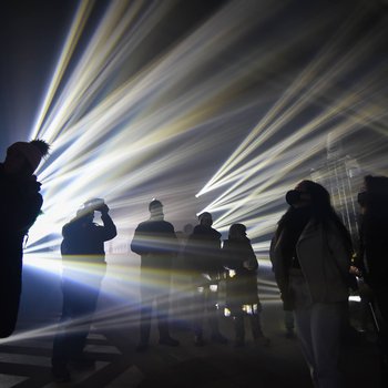 A group of people stood in a dark church surrounded by an array of lights