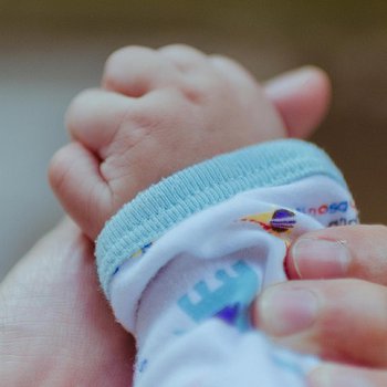 parent's hand holding baby's hand