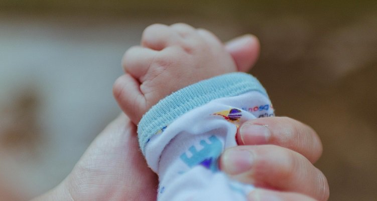 Image of baby hand gripping a mother's hand
