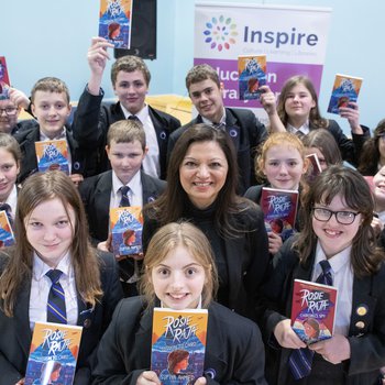 three school children hold copies of Rosie Raja the book
