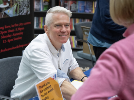 Author T.M. Logan talking to an audience member at an event