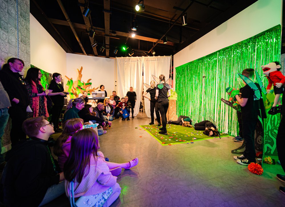 Children dressed in fairy wings performing a midsummer night's dream to the public