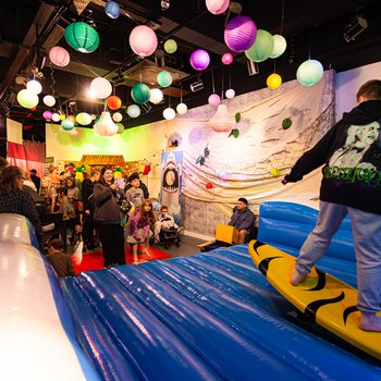 A boy on a inflatable surf board bouncy castle