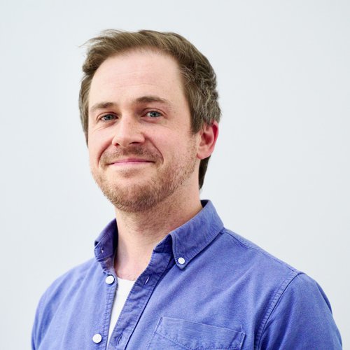 A headshot image of a man smiling to the camera.