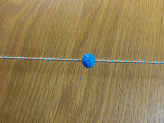 A bead in the middle of a piece of twisty string