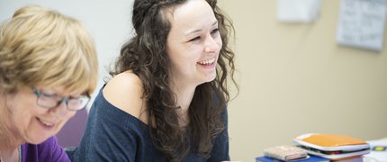 smiling_woman_with_black_hair_learning_at_a_library