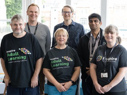 A group of Inspire Learning tutors standing together and posing for a group photo
